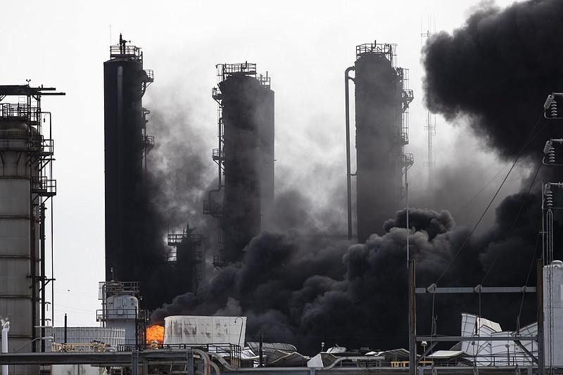 Smoke and fire are visible from the TPC Group Port Neches Operations explosion on Wednesday, Nov. 27, 2019, in Port Neches, Texas.  Three workers were injured early Wednesday in a massive explosion at the Texas chemical plant that also blew out the windows and doors of nearby homes.  (Marie D. De Jesus /Houston Chronicle via AP)