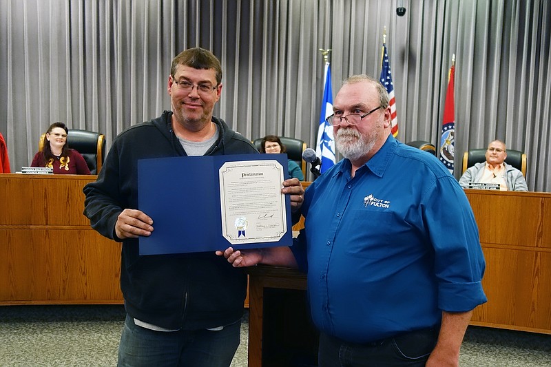 Gary Blackburn Jr., left, along with members of the Fulton Garden Club and the Fulton utilities department, were recognized Tuesday for their role in the creation and placement of the city's new giant holiday tree decoration. Rick Shiverdecker, deputy mayor, read proclamations recognizing the groups.