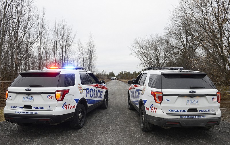 Two Kingston Police cars block a road leading to the site of a fatal plane crash in Kingston, Ontario, on Thursday, Nov. 28, 2019. (Sean Kilpatrick/The Canadian Press via AP)