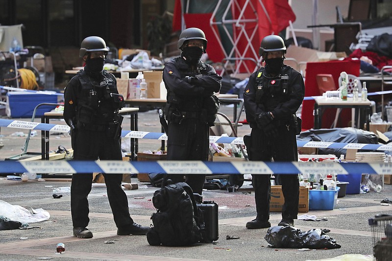 Bomb disposal police watch from a cordoned area as evidence is collected in a cordoned off area in the Polytechnic University campus in Hong Kong, Thursday, Nov. 28, 2019. Police safety teams Thursday began clearing a university that was a flashpoint for clashes with protesters, and an officer said any holdouts still hiding inside would not be immediately arrested. (AP Photo/Ng Han Guan)