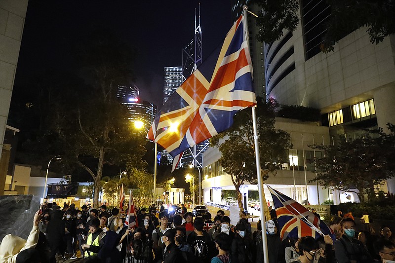 Protesters wave a British flag as they gather for a rally outside of the British Consulate in Hong Kong, Friday, Nov. 29, 2019. Hong Kong police ended their blockade of a university campus Friday after surrounding it for 12 days to try to arrest anti-government protesters holed up inside. (AP Photo/Vincent Thian)