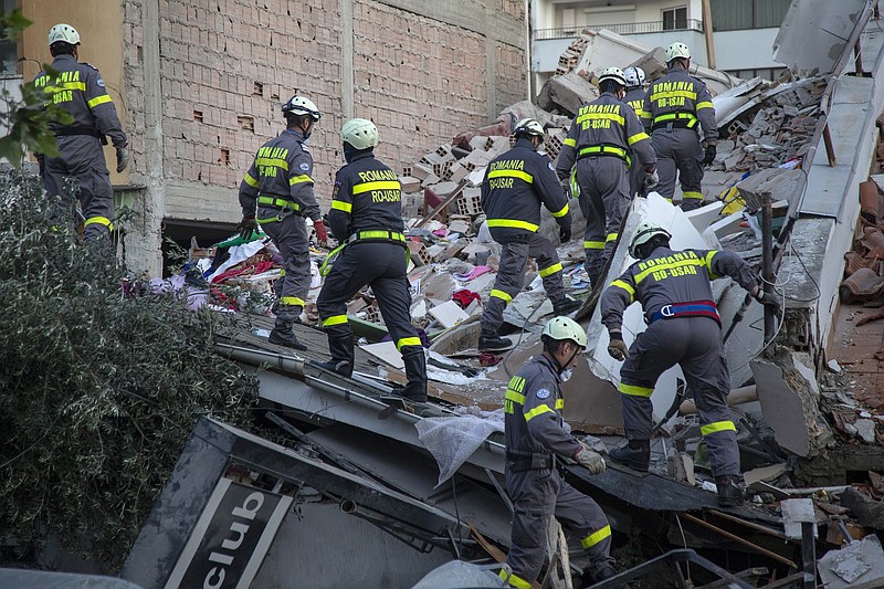 In this photo taken on Wednesday, Nov. 27, 2019, rescuers from Romania operate at a collapsed building after the 6.4-magnitude earthquake in Durres, western Albania. In the initial hours after a deadly pre-dawn earthquake struck Albania, pancaking buildings and trapping dozens of sleeping people beneath the rubble, the country’s neighbors sprang into action. Offers of help flooded in from across Europe and beyond, with even traditional foes setting aside their differences in the face of the natural disaster. The 6.4-magnitude earthquake that struck Albania on Tuesday killed at least 49 people, injured 2,000 and left at least 4,000 homeless. (AP Photo/Visar Kryeziu)