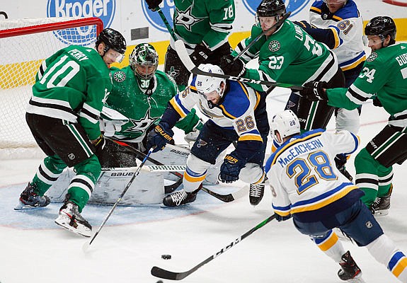 Blues forwards Mackenzie MacEachern (28) and Nathan Walker (26) battle a slew of Stars for the puck during Friday night's game in Dallas,
