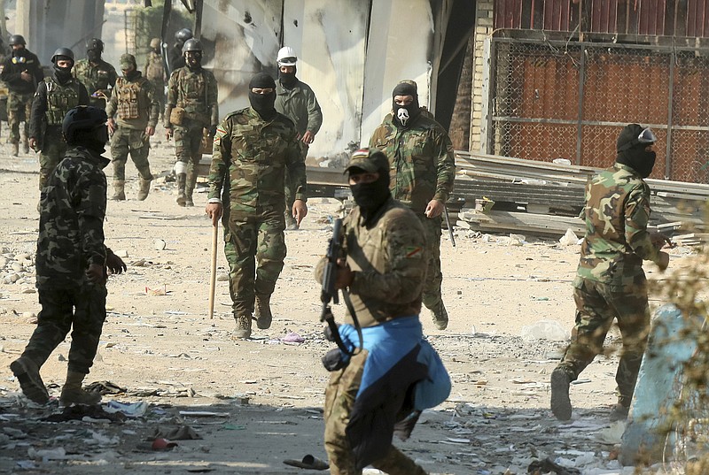 Security forces try to disperse anti-government protesters during clashes in Baghdad, Iraq, Saturday, Nov. 30, 2019. (AP Photo/Hadi Mizban)