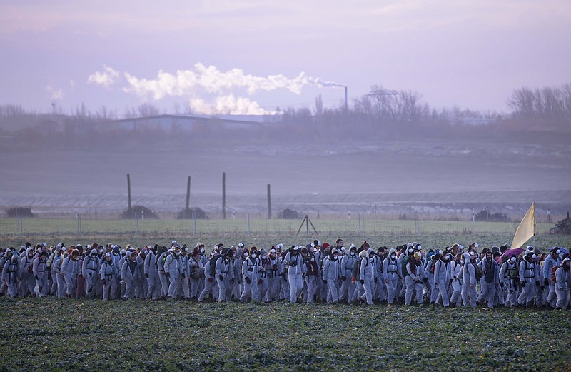 Supporters of the climate movement Ende Gelaende protest in front of a coal-fired power station Lippendorf near Leipzig, Germany, Sunday, Nov. 24, 2019. Ende Gelaende is an action alliance for an immediate coal exit, climate justice and a fundamental system change. The alliance announces a mass action of civil disobedience in the Saxony and Lusatian coal mining area in Germany. (AP Photo/Jens Meyer)