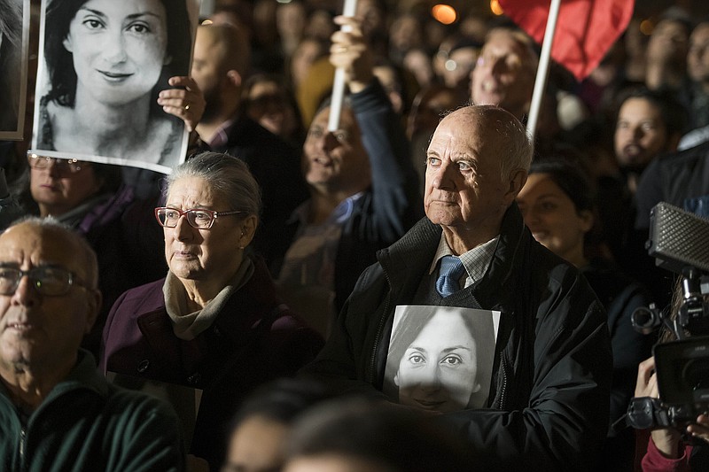 Rose and Michael Vella hold photos of their daughter, assassinated investigative journalist Daphne Caruana Galizia, as they partecipate in a demonstration in Valletta, Malta, Friday night, Nov. 29, 2019.  The family of the journalist who was killed by a car bomb in Malta is urging Maltese Prime Minister Joseph Muscat to resign, after his former chief aide was released from jail in a probe aimed at finding the mastermind of the 2017 murder. (AP Photo/Rene' Rossignaud)