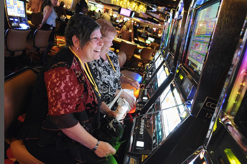 FILE - In this July 15, 2011 file photo, patrons plays the slots during a special VIP event at the new Rivers Casino in Des Plaines, Ill.  Even though Illinois lawmakers have finally approved a Chicago casino, the city faces major obstacles before anyone can place any bets. One of the biggest issues is trying to make it more profitable. Lawmakers adjourned their veto session this month without addressing the issue. Mayor Lori Lightfoot says they'll try again in January. (Mark Welsh/Daily Herald via AP, File)