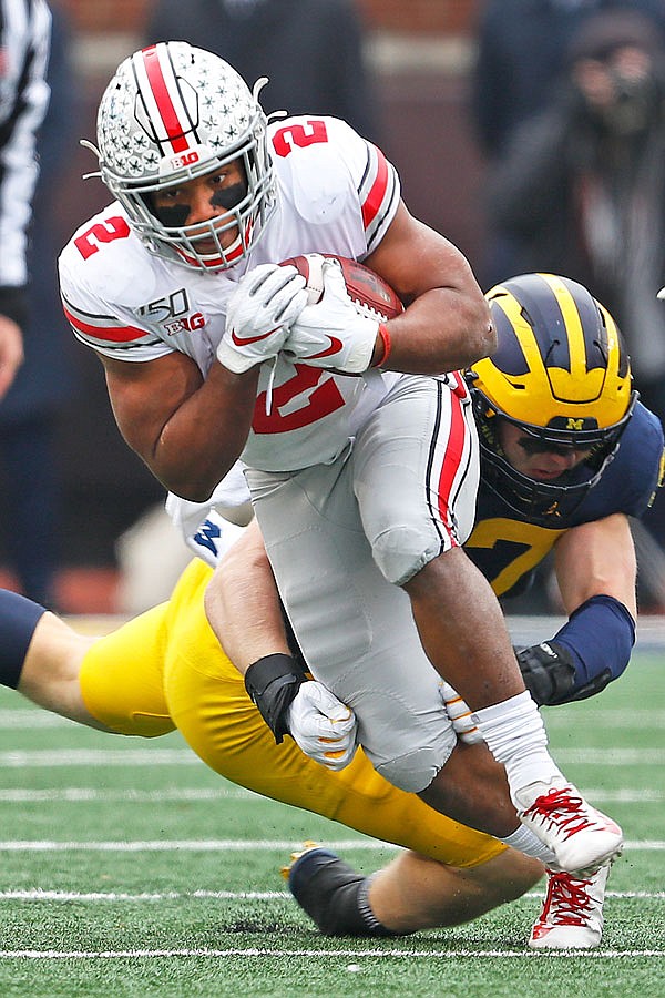 Ohio State running back J.K. Dobbins escapes the tackle of Michigan defensive lineman Aidan Hutchinson in the first half of Saturday's game in Ann Arbor, Mich.
