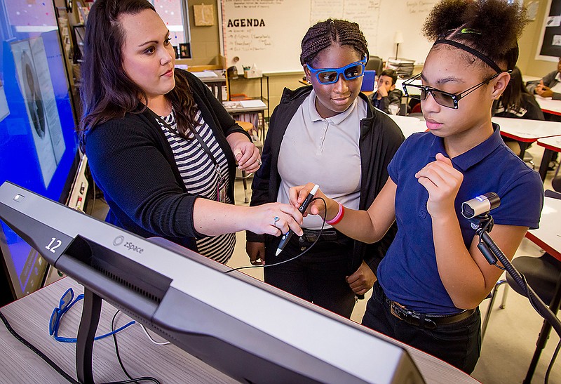 Lesley Bozman, left, introduces students Nicia Luna, right, and Keiandra Wilson to zSpace, an augmented reality learning environment, Monday, Oct. 14, 2019, at Forest Park Middle School in Longview, Texas. (Les Hassell/The News-Journal via AP)