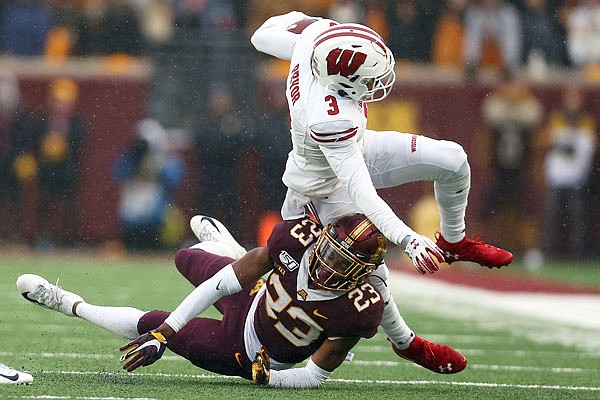 Wisconsin wide receiver Kendric Pryor is knocked down by Minnesota defensive back Jordan Howden during Saturday's game in Minneapolis.