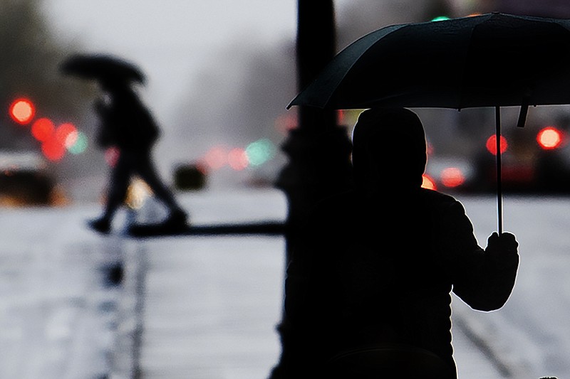 Pedestrians shield from the rain with an umbrellas during a cold rainy day in Center City, Sunday, Dec. 1, 2019 in Philadelphia. (Jose F. Moreno/The Philadelphia Inquirer via AP)