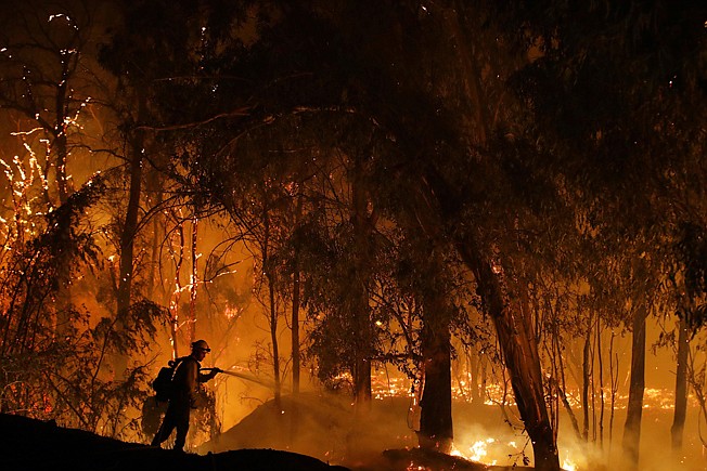 A firefighter battles the Maria Fire on Oct. 31 in Somis, Calif. Since leaders first started talking about tackling the problem of climate change, the world has spewed more heat-trapping gases, gotten hotter and suffered hundreds of extreme weather disasters. Fires have burned, ice has melted and seas have grown.