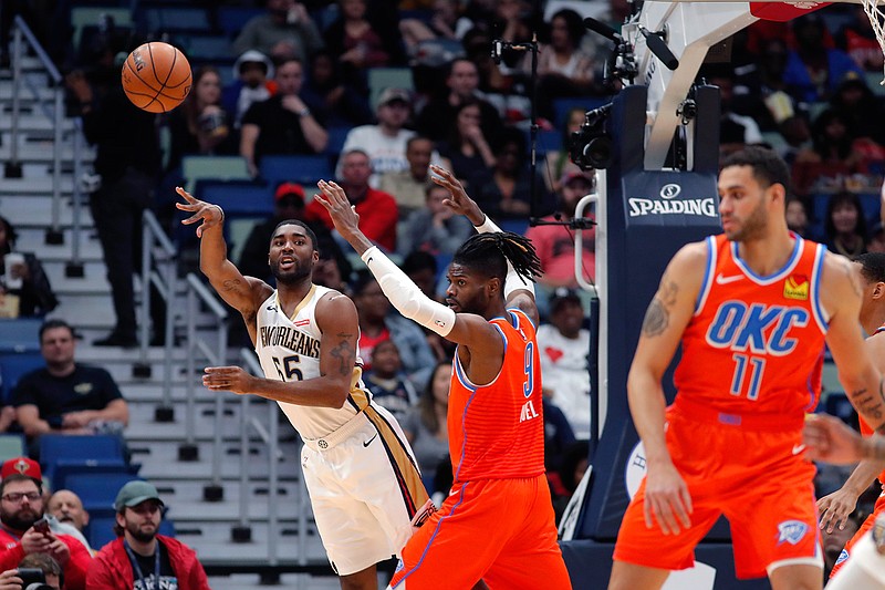 New Orleans Pelicans guard E'Twaun Moore (55) passes around Oklahoma City Thunder center Nerlens Noel (9) in the first half of an NBA game in New Orleans.