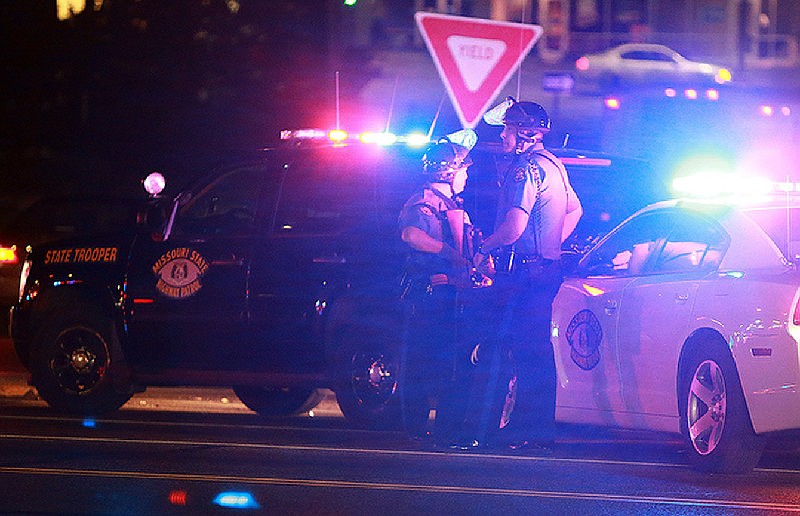 ARCHIVE PHOTO: Missouri State Highway Patrol troopers stand posted at the corner of Chambers Road and West Florissant Avenue on Saturday, Sept. 27, 2014, in Ferguson, Mo., as police search for a suspect in the shooting of a Ferguson police officer. Ferguson had been the scene of unrest since the Aug. 9, 2014, shooting of Michael Brown, a black 18-year-old, by a white police officer. (AP Photo/St. Louis Post-Dispatch, Christian Gooden)