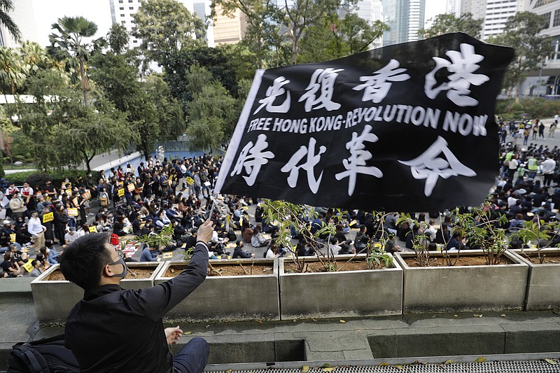 A pro-democracy supporter waves a flag during a rally by the advertising industry in Hong Kong on Monday, Dec. 2, 2019. Thousands of people took to Hong Kong's streets Sunday in a new wave of pro-democracy protests, but police fired tear gas after some demonstrators hurled bricks and smoke bombs, breaking a rare pause in violence that has persisted during the six-month-long movement. (AP Photo/Vincent Thian)