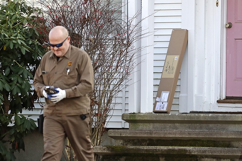 In this Nov. 26, 2019, photo a UPS man delivers a package to a residence in North Andover, Mass.  “Cyber Monday” is still holding up as the biggest online shopping day of the year, even though the same deals have been available online for weeks and the name harks back to the days of dial-up modems. (AP Photo/Elise Amendola)