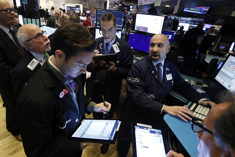 FILE - In this Nov. 14, 2019, file photo specialist James Denaro, right, works with traders at his post on the floor of the New York Stock Exchange. The U.S. stock market opens at 9:30 a.m. EST on Monday, Dec. 2. (AP Photo/Richard Drew, File)