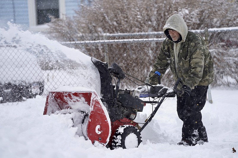 Keith Standring clears snow for The Alternative Living Center in Pittsfield, Massachussetts, following an overnight snowstorm Monday.