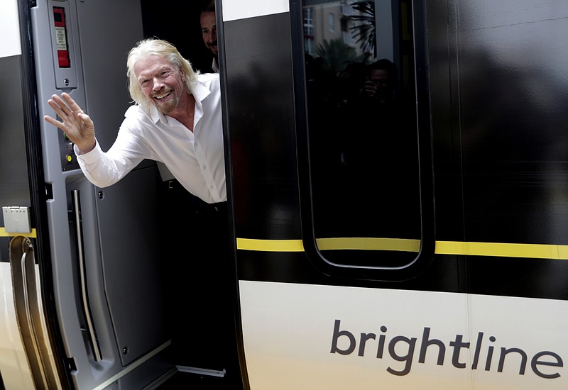 FILE - In this April 4, 2019, file photo Richard Branson, of Virgin Group, waves as he arrives on a Brightline train in West Palm Beach, Fla. The Brightline, a higher-speed passenger train service tied to Richard Branson's Virgin Group, has the worst per-mile death rate in the U.S. . (AP Photo/Lynne Sladky, File)