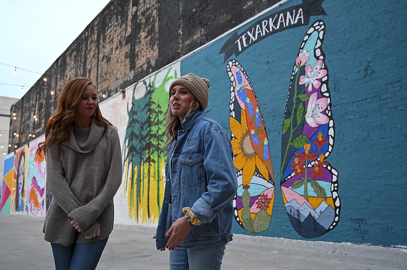 Molly Kendrick, left, and Rachel Freeman bring butterfly beauty and floral creativity to the mural project on Broad Street in downtown Texarkana