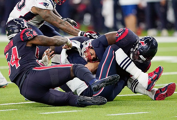 Patriots quarterback Tom Brady is sacked by Texans linebacker Jake Martin (54) and defensive end Charles Omenihu (94) during the second half of Sunday night's game in Houston.