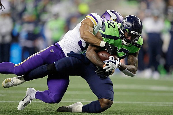 Chris Carson of the Seahawks is brought down by Eric Wilson of the Vikings on a 26-yard carry during the second half of Monday night's game in Seattle.