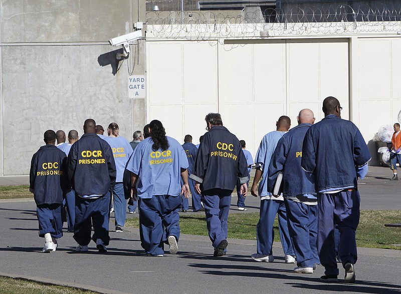 FILE - In this Feb. 26, 2013, file photo, inmates walk through the exercise yard at California State Prison Sacramento, near Folsom, Calif. Racial disparities have narrowed across the United States criminal justice system since 2000, though blacks remain significantly more likely to be impacted than whites, according to a study released Tuesday, Dec. 3, 2019, by the nonpartisan Council on Criminal Justice. (AP Photo/Rich Pedroncelli, File)