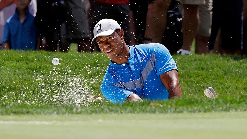  In this Thursday, Aug. 15, 2019 file photo, Tiger Woods hits from a sand trap on the fourth hole during the first round of the BMW Championship golf tournament at Medinah Country Club in Medinah, Ill. Woods is in the Bahamas this week as a player and a host, and in Australia next week as a player and Presidents Cup captain. (AP Photo/Nam Y. Huh, File)