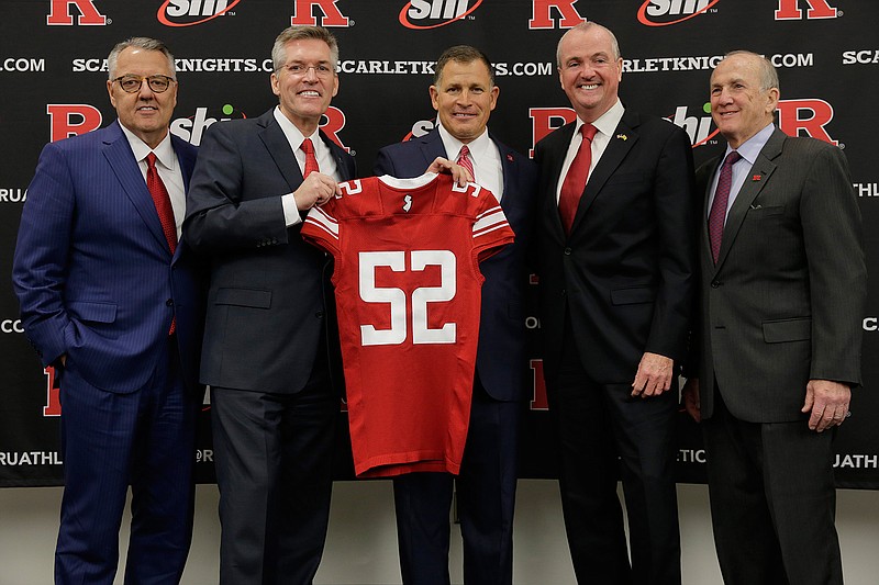 New Rutgers NCAA college football head coach Greg Schiano, center, poses for a picture with Greg Brown, chairman of the Committee on Intercollegiate Athletics, left, Rutgers athletic director Pat Hobbs, second from left, New Jersey Gov. Phil Murphy, second from right, and Rutgers president Robert Barchi, right, after an introductory news conference in Piscataway, N.J., Wednesday, Dec. 4, 2019. After an on-again, off-again courtship, Schiano is back as Rutgers football coach. (AP Photo/Seth Wenig)