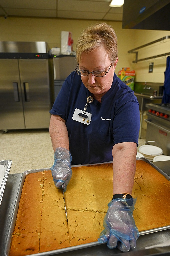 Sandra Hart cuts cornbread into smaller pieces to serve at the 21st annual Bramlett Beans and Cornbread fundraiser Thursday, Dec. 5, 2019, at Southwest Center in Texarkana, Texas. 