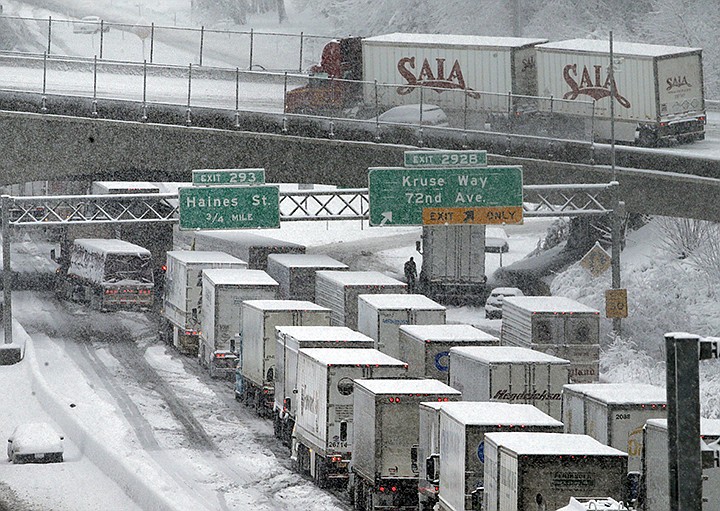 FILE - In this Jan. 11, 2017, file photo, eEarly morning traffic is at a standstill on Interstate 5 headed into town as a semi truck and cars block the off ramp to Highway 217 above in Portland, Ore. A federal watchdog says the Trump administration moved to exempt a type of super-polluting cargo truck from clean air rules without conducting a federally mandated study on how it would impact public health. The report by the Environmental Protection Agency's inspector-general says agency officials cited a "wild West" atmosphere and "fast and loose" rulemaking at the agency under then-Administrator Scott Pruitt. (AP Photo/Don Ryan, File)