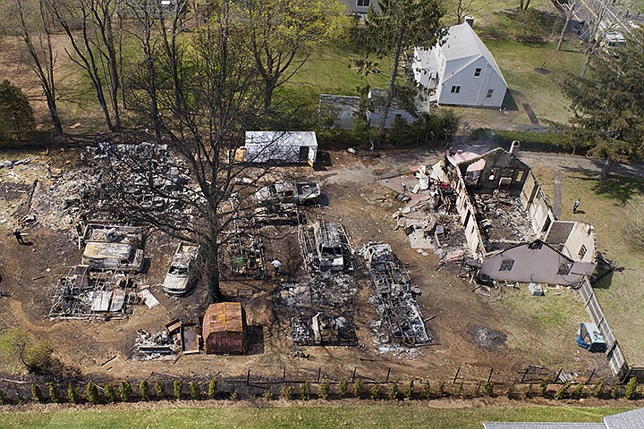FILE - In this May 3, 2018 file photo, emergency personnel work at the scene of an explosion in North Haven, Conn. Newly released reports are shedding more light on an explosion during a police standoff in Connecticut last year that killed a man and injured nine officers. John Sayre Sr. was killed in the blast in a barn behind his home. (John Woike/Hartford Courant via AP, File)