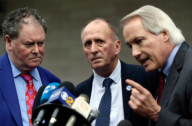 British cave explorer Vernon Unsworth, center, with his attorneys, Mark Stephens, left, and Lin Wood, take questions from the media outside U.S. District Court Friday, Dec. 6, 2019. Elon Musk did not defame Unsworth when he called him "pedo guy" in an angry tweet, a Los Angeles jury found Friday. Unsworth, who participated in the rescue of 12 boys and their soccer coach trapped for weeks in a Thailand cave last year, had angered the Tesla CEO by belittling his effort to help with the rescue as a "PR stunt." (AP Photo/Damian Dovarganes)