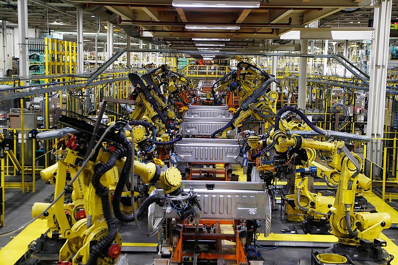 In this Sept. 27, 2018, file photo robots weld the bed of a Ford F Series trucks on the assembly line at the Ford Rouge assembly plant in Dearborn, Mich. Ford Motor Co. is recalling nearly 262,000 heavy-duty pickup trucks in the U.S. and Canada because the tailgates can open unexpectedly. The recall covers F-250, F-350 and F-450 trucks from the 2017 through 2019 model years. All the trucks have electric tailgate latch release switches in the tailgate handle. (AP Photo/Carlos Osorio, File)