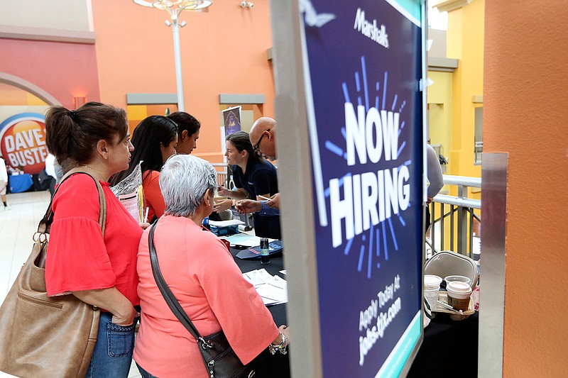 In this Oct. 1, 2019, file photo people wait in line to inquire about job openings with Marshalls during a job fair at Dolphin Mall in Miami. On Friday, Dec. 6, the U.S. government issues the November jobs report. (AP Photo/Lynne Sladky, File)