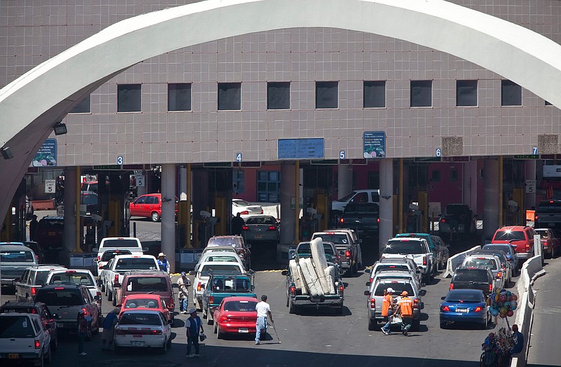 This June 1, 2009, file photo, shows vehicles waiting to enter the U.S. through The Dennis DeConcini Port of Entry in downtown Nogales, Ariz. For months, the U.S. has barred asylum seekers from approaching official crossings to file a claim. Now, some are rushing the ports by running through vehicle lanes to evade the process used to officially request asylum. That is causing massive delays at crossings in Arizona as U.S. Customs and Border Protection officials have barricaded lanes used by cars to legally enter the U.S. (Mark Henle/The Arizona Republic via AP, File)