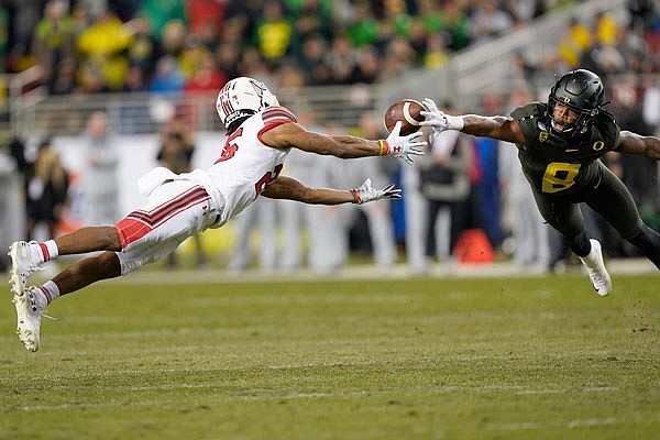 Oregon safety Jevon Holland (right) breaks up a pass for Utah wide receiver Jaylen Dixon during the first half of Friday night's Pac-12 Conference championship game in Santa Clara, Calif.