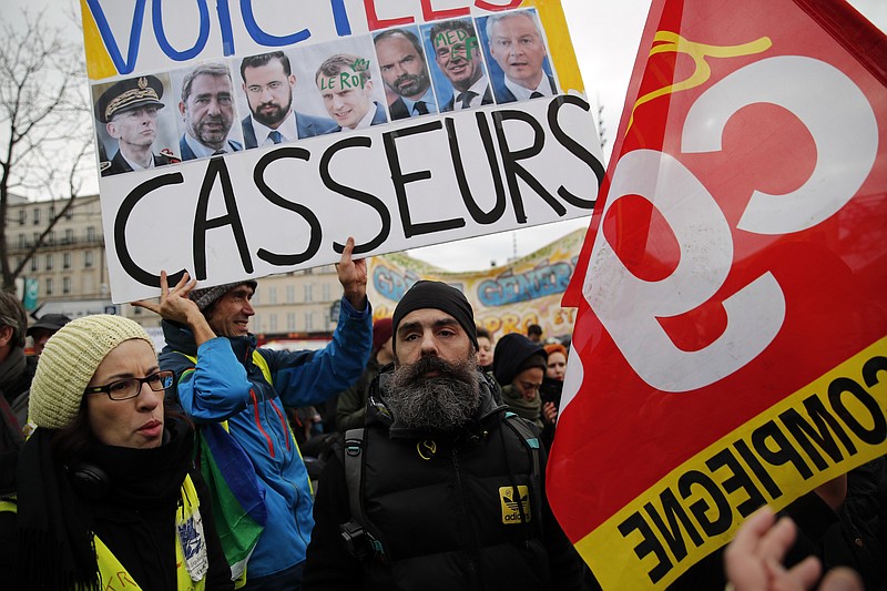 Jerome Rodrigues, one of the leading figures of the yellow vests movement, center, attends a demonstration during their 56th round in Paris, Saturday, Dec. 7, 2019. A few thousand yellow vest protesters marched Saturday from the Finance Ministry building on the Seine River through southeast Paris, pushing their year-old demands for economic justice and adding the retirement reform to their list of grievances. (AP Photo/Francois Mori)