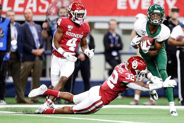 Baylor wide receiver Tyquan Thornton makes a catch as Oklahoma cornerback Jaden Davis (4) and safety Delarrin Turner-Yell (32) defend during Saturday's Big 12 title game in Arlington, Texas.