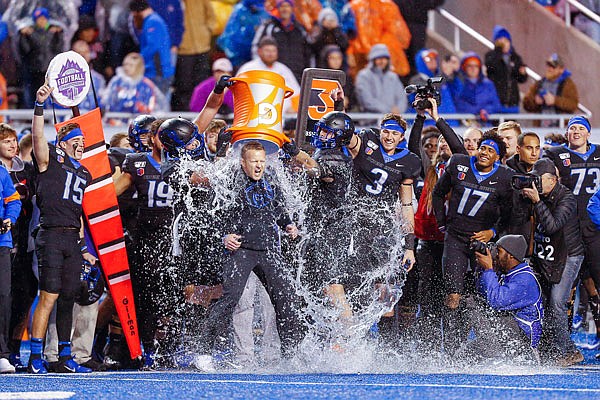 Boise State coach Bryan Harsin has water dumped on him Saturday after winning the Mountain West title game against Hawaii in Boise, Idaho.