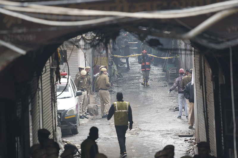 Police officers cordon off the site of a fire in a narrow lane in New Delhi, India, Sunday, Dec. 8, 2019. A doctor at a government-run hospital says dozens have died in a major fire in central New Delhi. (AP Photo/Manish Swarup)