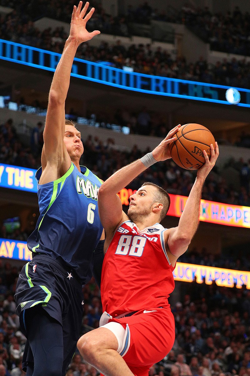 Dallas Mavericks forward Kristaps Porzingis (6) tries to defend against a shot by Sacramento Kings forward Nemanja Bjelica (88) in the second half of an NBA basketball game Sunday, Dec. 8, 2019, in Dallas. (AP Photo/Richard W. Rodriguez)