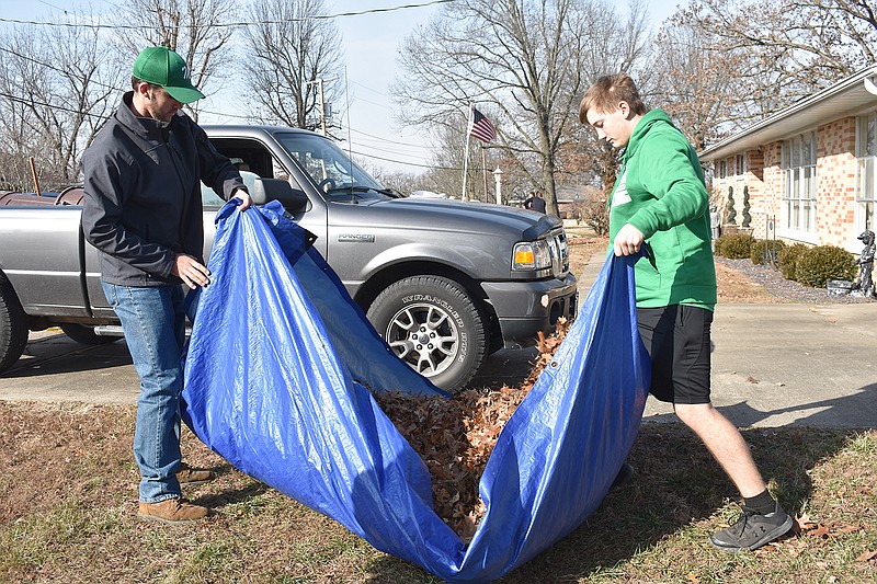 Blair Oaks High School students Nick Welch, left, and Devin Koelling move leaves in a tarp Sunday during the final day of Operation Leaf Relief. About a dozen area high school students helped Sunday with the final day of Operation Leaf Relief at the home of Mary Lou Scott, 921 Winston Drive. Money raised from raking leaves goes to Operation Bugle Boy. 