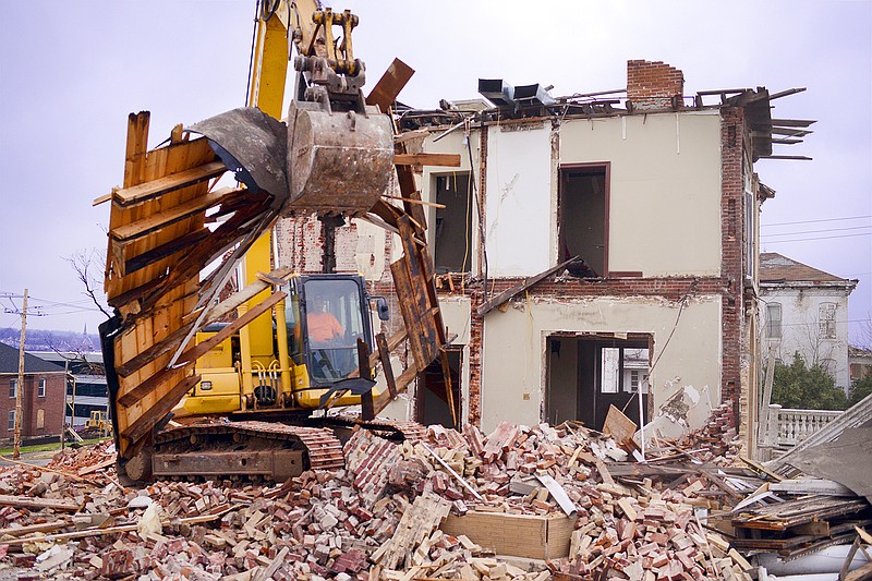 A contractor uses an excavator to pick up debris after half of the Dallmeyer House is demolished Monday at 600 E. Capitol Ave. The building, which housed Burkhead & Associates for the past 14 years, was heavily damaged in the May 22 tornado. 