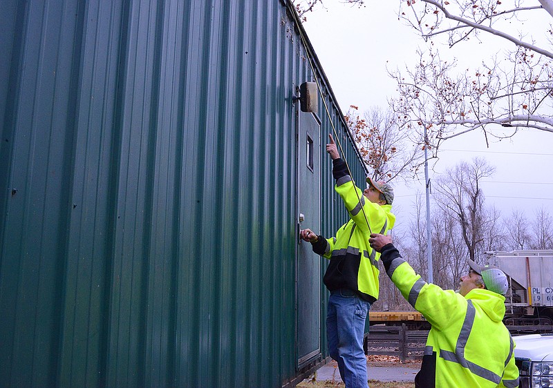Don Wolken, front, and Dennis Kramer, with the Public Works Department, take measurements outside a trailer Monday in the Lohman building parking lot. The trailer will be used temporarily by the Amtrak Train Station. 