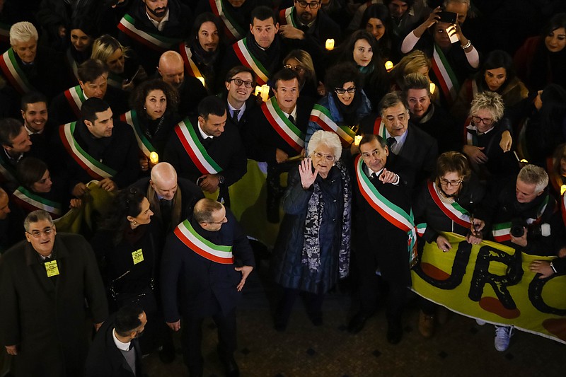 Liliana Segre, an 89-year-old Auschwitz survivor and senator-for-life, center, waves to photographers with Milan's Mayor Giuseppe Sala during an anti-racism demonstration in Milan's Victor Emmanuel II arcade in northern Italy that was joined by mayors of some 600 Italian towns, Tuesday, Dec. 10, 2019. In Italy, controversy flared recently when Segre called for the creation of a parliamentary committee to combat hate, racism and anti-Semitism after revelations that she is subject to some 200 social media attacks each day. (AP Photo/Luca Bruno)