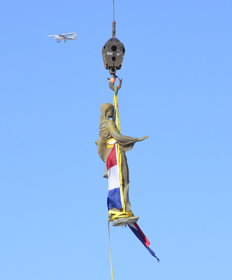 In this Nov. 15, 2018 photo, a statue of Ceres, the Roman goddess of agriculture, is lowered from the top of the Missouri Capitol in Jefferson City, Mo. State Rep. Mike Moon, an Ash Grove Republican, is asking Gov. Mike Parson to intervene and prevent the state from reinstalling the stature, claiming it represents a “false god." The statue was installed on the Capitol dome in 1924 and was taken down in November of last year as part of a $50 million project to renovate the Capitol's exterior. It is scheduled to be returned to the Capitol on Monday.  (Jack Suntrup/St. Louis Post-Dispatch via AP)