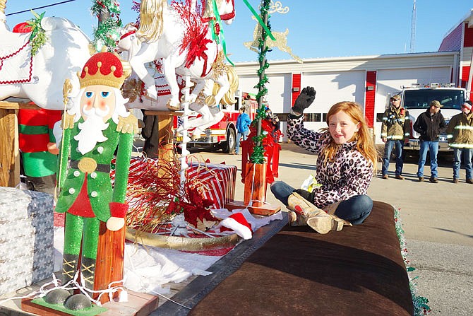 FILE: Gwen Witschev waves from the back of a float in the 2017 Holts Summit Christmas parade. This year's parade is at 4 p.m. Saturday.