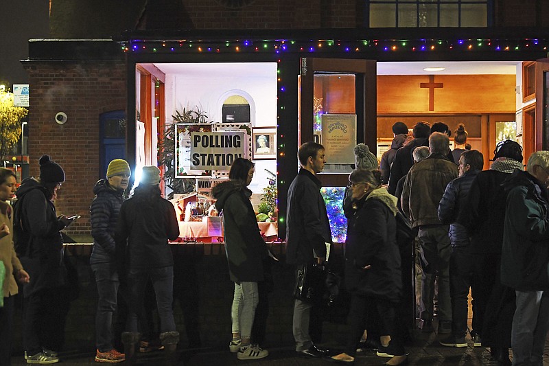 Voters queue outside St Andrews Church polling station in Balham, south London, just hours before voting closes for the 2019 General Election, Thursday, Dec. 12, 2019. Britons who have endured more than three years of wrangling over their country’s messy divorce from the European Union cast ballots Thursday in an election billed as a way out of the Brexit stalemate in this deeply divided nation. (Victoria Jones/PA via AP)