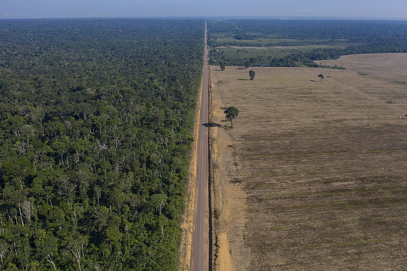 In this Nov. 25, 2019 photo, highway BR-163 stretches between the Tapajos National Forest, left, and a soy field in Belterra, Para state, Brazil. Carved through jungle during Brazil’s military dictatorship in the 1970s, this highway and BR-230, known as the Trans-Amazon, were built to bend nature to man’s will in the vast hinterland. Four decades later, there’s development taking shape, but also worsening deforestation. (AP Photo/Leo Correa)